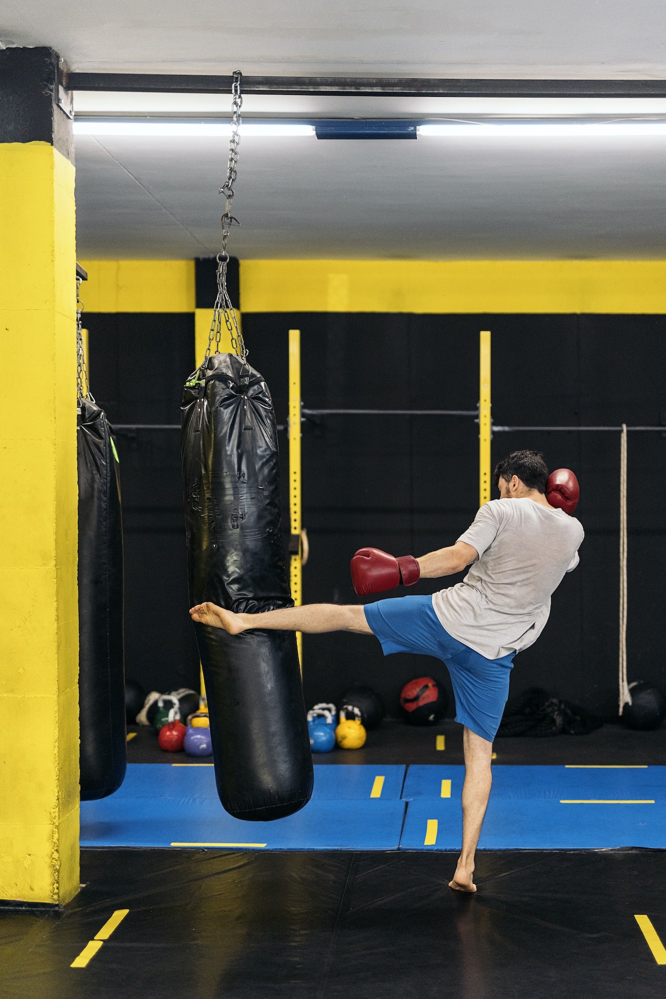 Kickboxing fighter performing Kicks with foot on punching bag at the gym