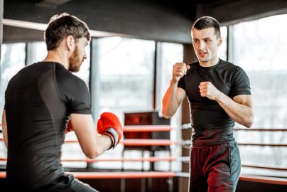 Boxing trainer with a man boxing at the gym